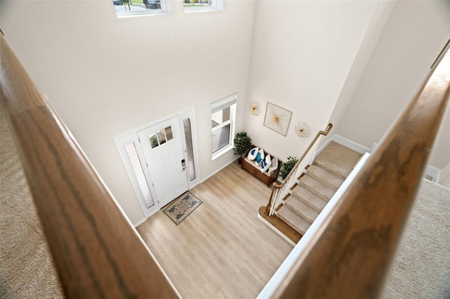 7163 Talamore Dr, Wesley Chapel, FL 33545 - entrance foyer featuring stairs, a towering ceiling, light wood-style flooring, and baseboards
