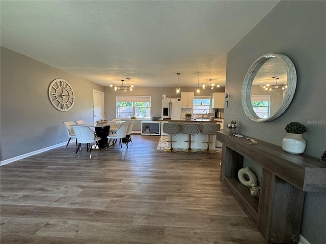 3702 Mirror Lake Dr, Apopka, FL 32703 - dining area featuring a chandelier, dark wood-style floors, and baseboards