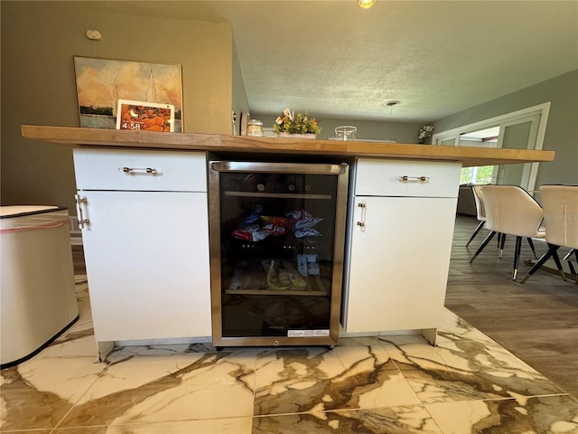 3702 Mirror Lake Dr, Apopka, FL 32703 - bar area featuring beverage cooler, a textured ceiling, and light marble finish floors