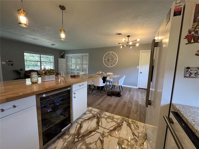 3702 Mirror Lake Dr, Apopka, FL 32703 - kitchen with beverage cooler, wooden counters, white cabinets, a textured ceiling, and a chandelier