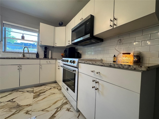 3702 Mirror Lake Dr, Apopka, FL 32703 - kitchen with white electric range, stainless steel microwave, a sink, light marble finish floors, and backsplash