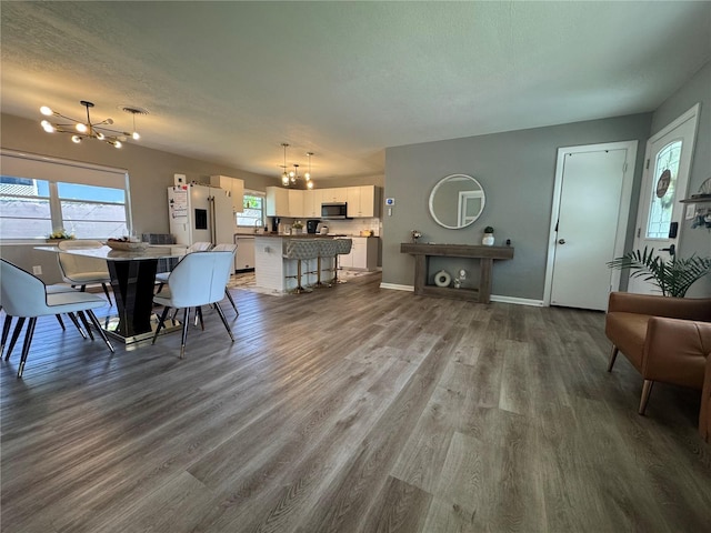 3702 Mirror Lake Dr, Apopka, FL 32703 - dining area with a chandelier, wood finished floors, baseboards, and a textured ceiling