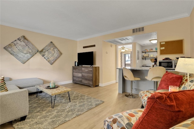 145 Oyster Bay Cir Unit 140, Altamonte Springs, FL 32701 - living area featuring crown molding, light wood-type flooring, ceiling fan, and baseboards