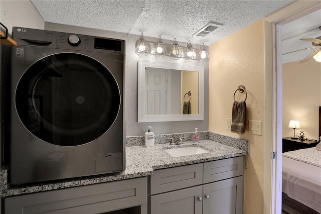 145 Oyster Bay Cir Unit 140, Altamonte Springs, FL 32701 - bathroom featuring washer / dryer, a textured ceiling, double vanity, a textured wall, and ceiling fan
