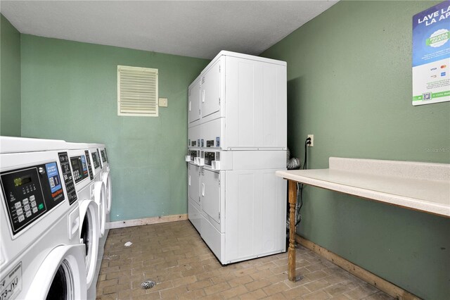 145 Oyster Bay Cir Unit 140, Altamonte Springs, FL 32701 - community laundry room featuring stacked washer and clothes dryer, washer and clothes dryer, brick patterned floors, and baseboards