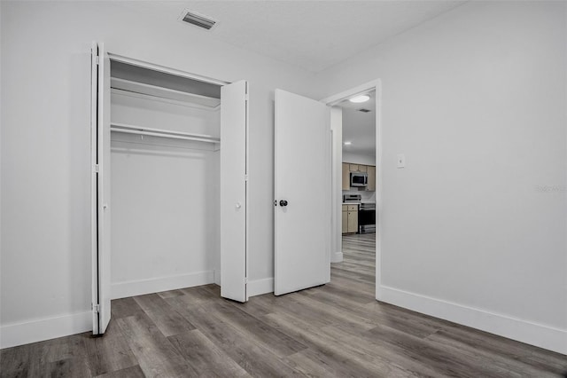 418 Tulane Dr, Altamonte Springs, FL 32714 - unfurnished bedroom featuring wood finished floors, baseboards, and a closet