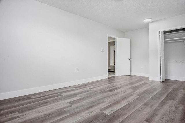 418 Tulane Dr, Altamonte Springs, FL 32714 - unfurnished bedroom featuring wood finished floors, a closet, a textured ceiling, and baseboards