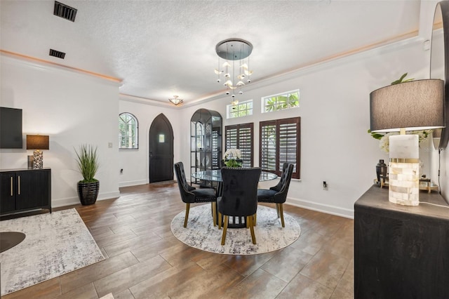 602 E Livingston St Unit 3, Orlando, FL 32803 - dining area with arched walkways, ornamental molding, baseboards, a chandelier, and wood finished floors