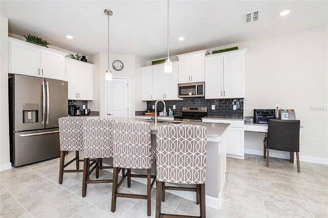 9106 Cut Shot Dr, Winter Garden, FL 34787 - kitchen with appliances with stainless steel finishes, a kitchen breakfast bar, backsplash, a kitchen island with sink, and recessed lighting