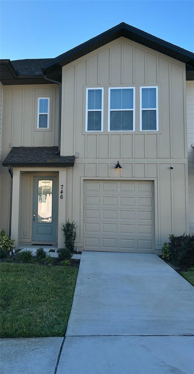 746 Longboat Dr, Davenport, FL 33896 - view of front of home with board and batten siding, concrete driveway, and an attached garage
