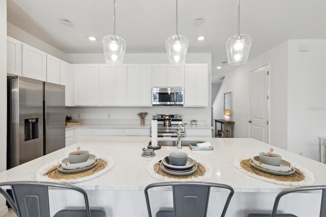 746 Longboat Dr, Davenport, FL 33896 - kitchen with appliances with stainless steel finishes, a breakfast bar area, white cabinets, a spacious island, and recessed lighting