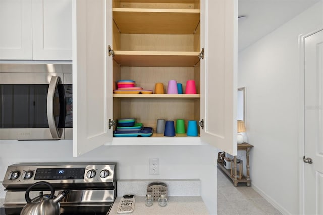 746 Longboat Dr, Davenport, FL 33896 - kitchen view of stainless steel appliances, white cabinetry, and open shelves