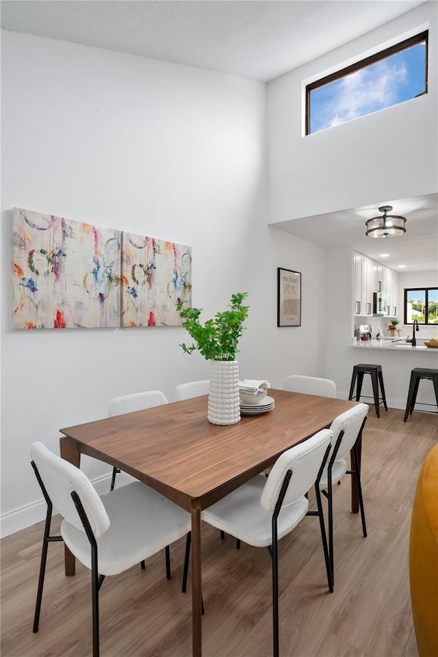 2541 Leeward Way, Winter Park, FL 32792 - dining space featuring light wood-style flooring, a towering ceiling, and a chandelier