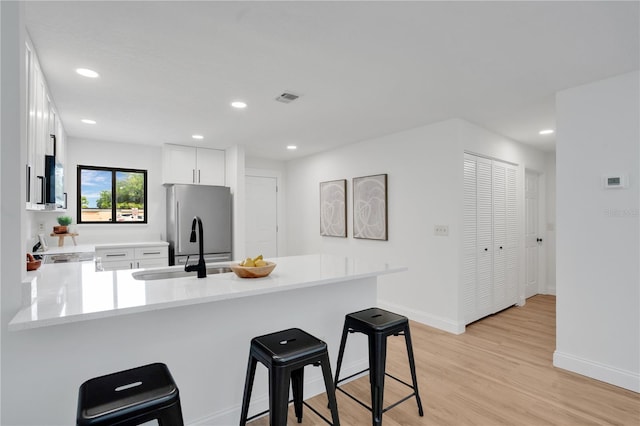 2541 Leeward Way, Winter Park, FL 32792 - kitchen featuring stainless steel refrigerator, a kitchen breakfast bar, a peninsula, light countertops, and a sink