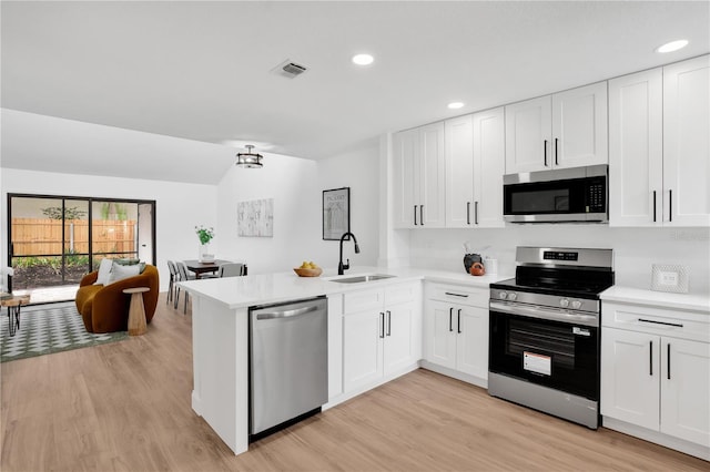 2541 Leeward Way, Winter Park, FL 32792 - kitchen featuring stainless steel appliances, a sink, light wood-style floors, light countertops, and a peninsula