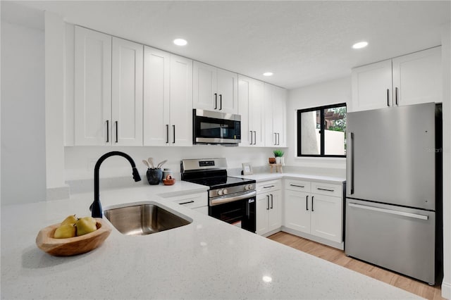 2541 Leeward Way, Winter Park, FL 32792 - kitchen with stainless steel appliances, a sink, recessed lighting, white cabinetry, and light stone countertops