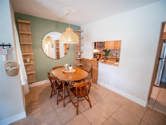 952 Courtyard Ln Unit 41, Orlando, FL 32825 - dining area with light tile patterned floors, baseboards, and a chandelier