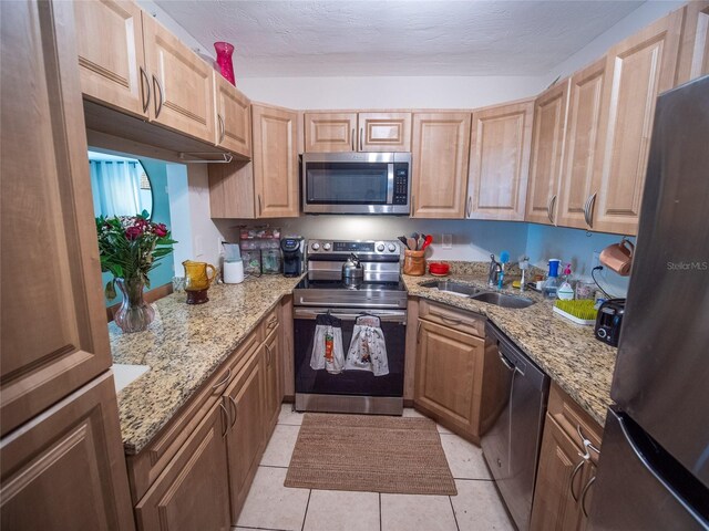 952 Courtyard Ln Unit 41, Orlando, FL 32825 - kitchen featuring stainless steel appliances, a sink, light tile patterned flooring, and light stone counters
