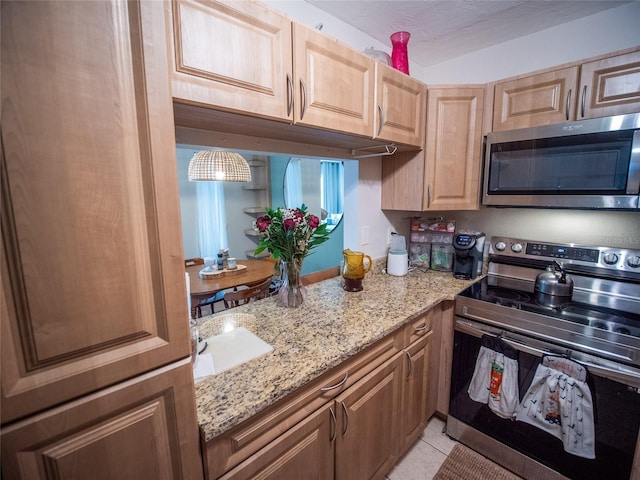 952 Courtyard Ln Unit 41, Orlando, FL 32825 - kitchen with stainless steel appliances, a sink, light stone counters, and light tile patterned flooring