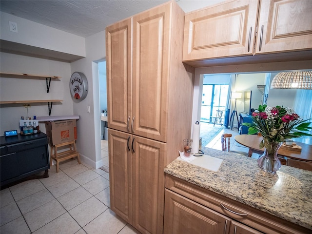 952 Courtyard Ln Unit 41, Orlando, FL 32825 - kitchen featuring light tile patterned flooring, light stone countertops, baseboards, and open shelves