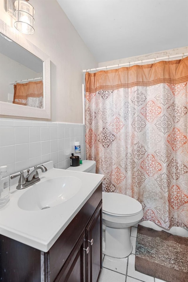2044 W Gore St, Orlando, FL 32805 - full bathroom featuring tile patterned floors, vanity, lofted ceiling, tile walls, and toilet
