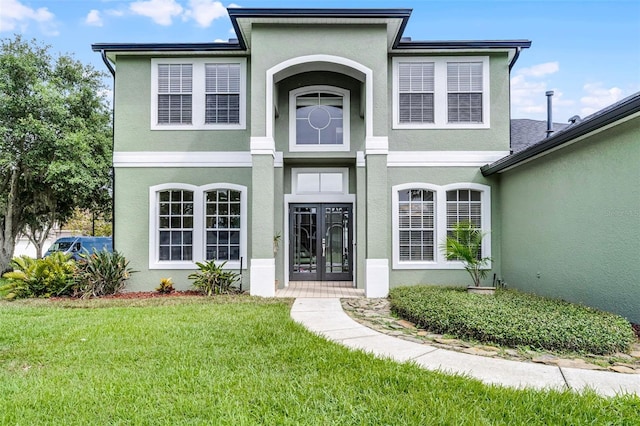 201 Hammock Dunes Pl, Orlando, FL 32828 - entrance to property with stucco siding, french doors, and a lawn