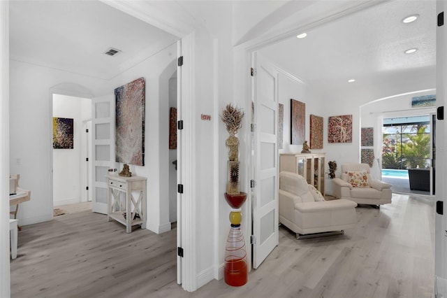 16120 Bristol Lake Cir, Orlando, FL 32828 - hallway featuring arched walkways, light wood-style flooring, recessed lighting, and baseboards
