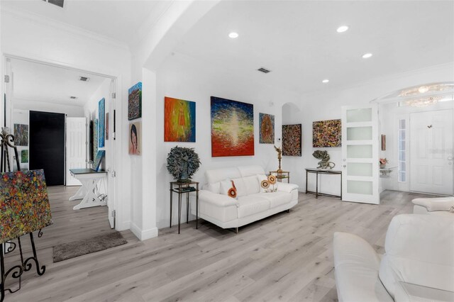 16120 Bristol Lake Cir, Orlando, FL 32828 - living room with arched walkways, ornamental molding, light wood finished floors, recessed lighting, and a chandelier
