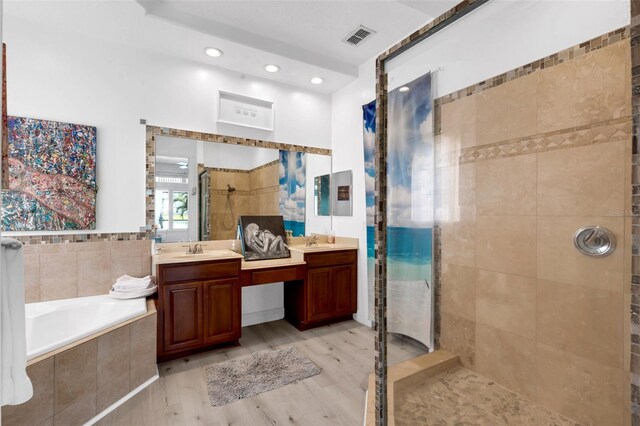 16120 Bristol Lake Cir, Orlando, FL 32828 - bathroom featuring a stall shower, double vanity, wood finished floors, a bath, and recessed lighting