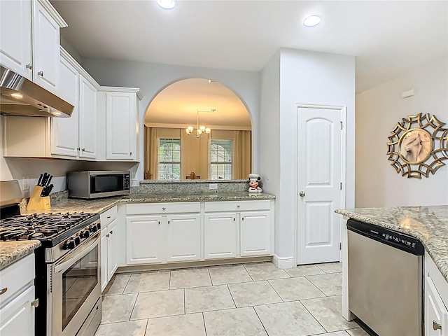 5255 Wildwood Way, Davenport, FL 33837 - kitchen featuring appliances with stainless steel finishes, arched walkways, under cabinet range hood, white cabinets, and light tile patterned floors