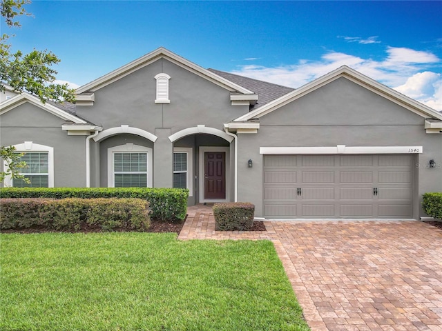 1540 Orange Valley Rdg, Ocoee, FL 34761 - view of front facade featuring stucco siding, a front yard, an attached garage, and decorative driveway