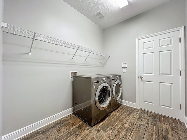 1540 Orange Valley Rdg, Ocoee, FL 34761 - laundry area with dark wood finished floors, washing machine and clothes dryer, baseboards, and a textured ceiling