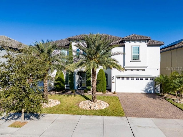 8085 Ludington Cir, Orlando, FL 32836 - mediterranean / spanish-style home featuring a tiled roof, an attached garage, decorative driveway, stucco siding, and a front yard