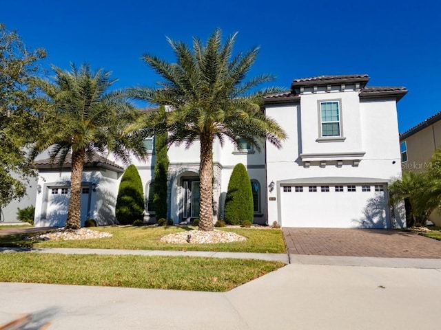 8085 Ludington Cir, Orlando, FL 32836 - mediterranean / spanish-style house featuring a garage, decorative driveway, a tiled roof, stucco siding, and a front lawn