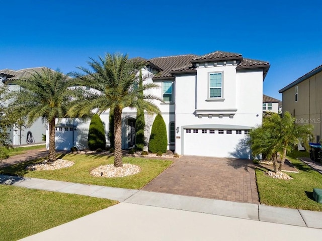 8085 Ludington Cir, Orlando, FL 32836 - mediterranean / spanish home with a tiled roof, an attached garage, decorative driveway, stucco siding, and a front yard
