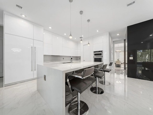 8085 Ludington Cir, Orlando, FL 32836 - kitchen with modern cabinets, white cabinets, light marble finish flooring, hanging light fixtures, and recessed lighting