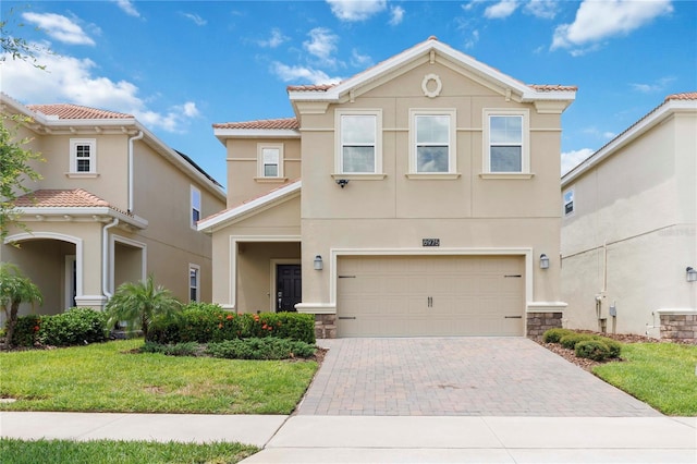 8975 Fluffy Lie Ct, Davenport, FL 33896 - view of front of home with stucco siding, decorative driveway, an attached garage, a tiled roof, and a front yard