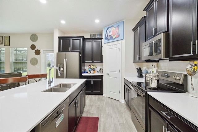 8975 Fluffy Lie Ct, Davenport, FL 33896 - kitchen featuring appliances with stainless steel finishes, light countertops, tasteful backsplash, light wood-type flooring, and recessed lighting