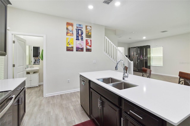 8975 Fluffy Lie Ct, Davenport, FL 33896 - kitchen featuring stainless steel appliances, light countertops, recessed lighting, a kitchen island with sink, and light wood-style flooring