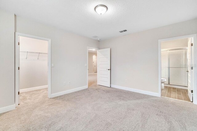 11063 Hollow Bay Dr, Winter Garden, FL 34787 - unfurnished bedroom with carpet, a walk in closet, a textured ceiling, baseboards, and a closet