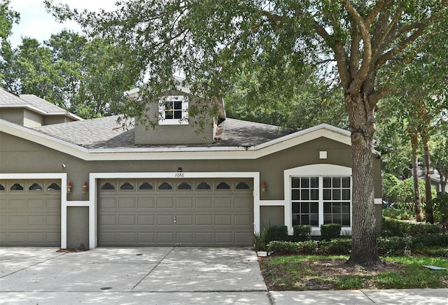 1086 Wickerwood St, Ocoee, FL 34761 - view of front of home featuring an attached garage, driveway, a shingled roof, and stucco siding