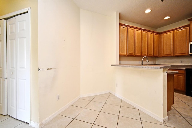 1086 Wickerwood St, Ocoee, FL 34761 - kitchen featuring light tile patterned floors, recessed lighting, brown cabinets, and a peninsula