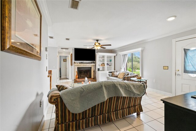 2112 Plymouth Sorrento Rd, Apopka, FL 32712 - living area with crown molding, light tile patterned floors, ceiling fan, a glass covered fireplace, and baseboards