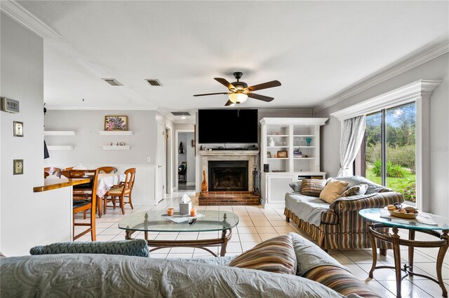 2112 Plymouth Sorrento Rd, Apopka, FL 32712 - living room featuring ornamental molding, ceiling fan, light tile patterned flooring, a brick fireplace, and a wainscoted wall