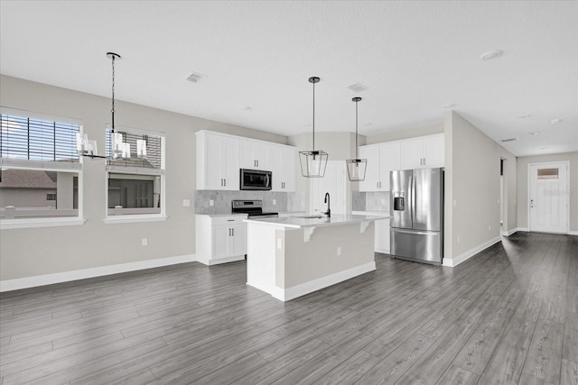 2311 Bear Peak Rd, Clermont, FL 34715 - kitchen with stainless steel appliances, open floor plan, backsplash, a chandelier, and dark wood finished floors