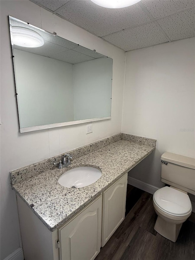 10301 US Highway 27 Unit 34, Clermont, FL 34711 - bathroom featuring vanity, wood finished floors, toilet, a paneled ceiling, and baseboards
