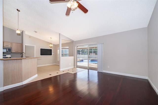 1115 Marni Ridge Ct, Kissimmee, FL 34747 - unfurnished living room featuring vaulted ceiling, ceiling fan, light wood-type flooring, and baseboards