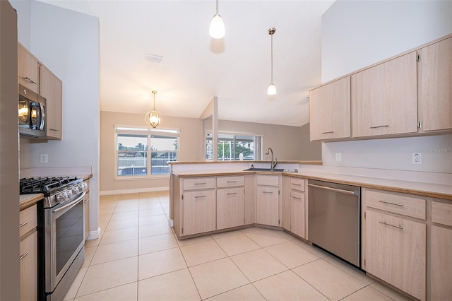 1115 Marni Ridge Ct, Kissimmee, FL 34747 - kitchen with appliances with stainless steel finishes, a sink, a peninsula, light countertops, and decorative light fixtures