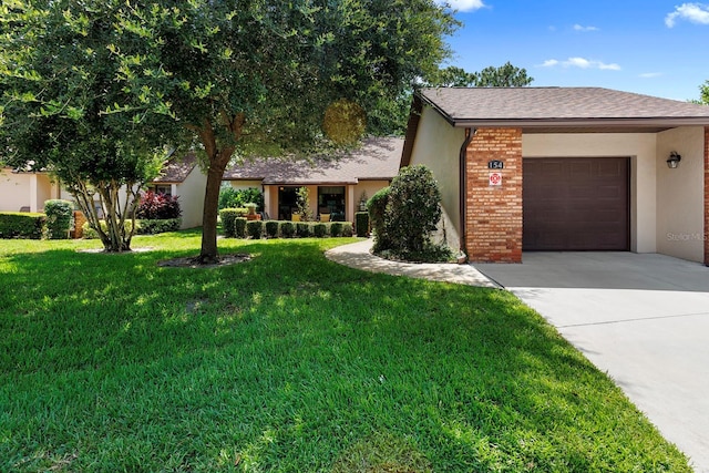 154 Golf Club Dr Unit 154, Longwood, FL 32779 - view of front of property with concrete driveway, an attached garage, a front lawn, brick siding, and stucco siding