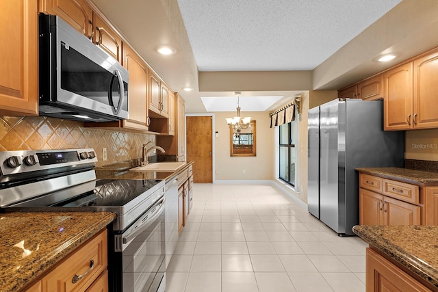 154 Golf Club Dr Unit 154, Longwood, FL 32779 - kitchen featuring stainless steel appliances, a chandelier, backsplash, dark stone countertops, and a textured ceiling